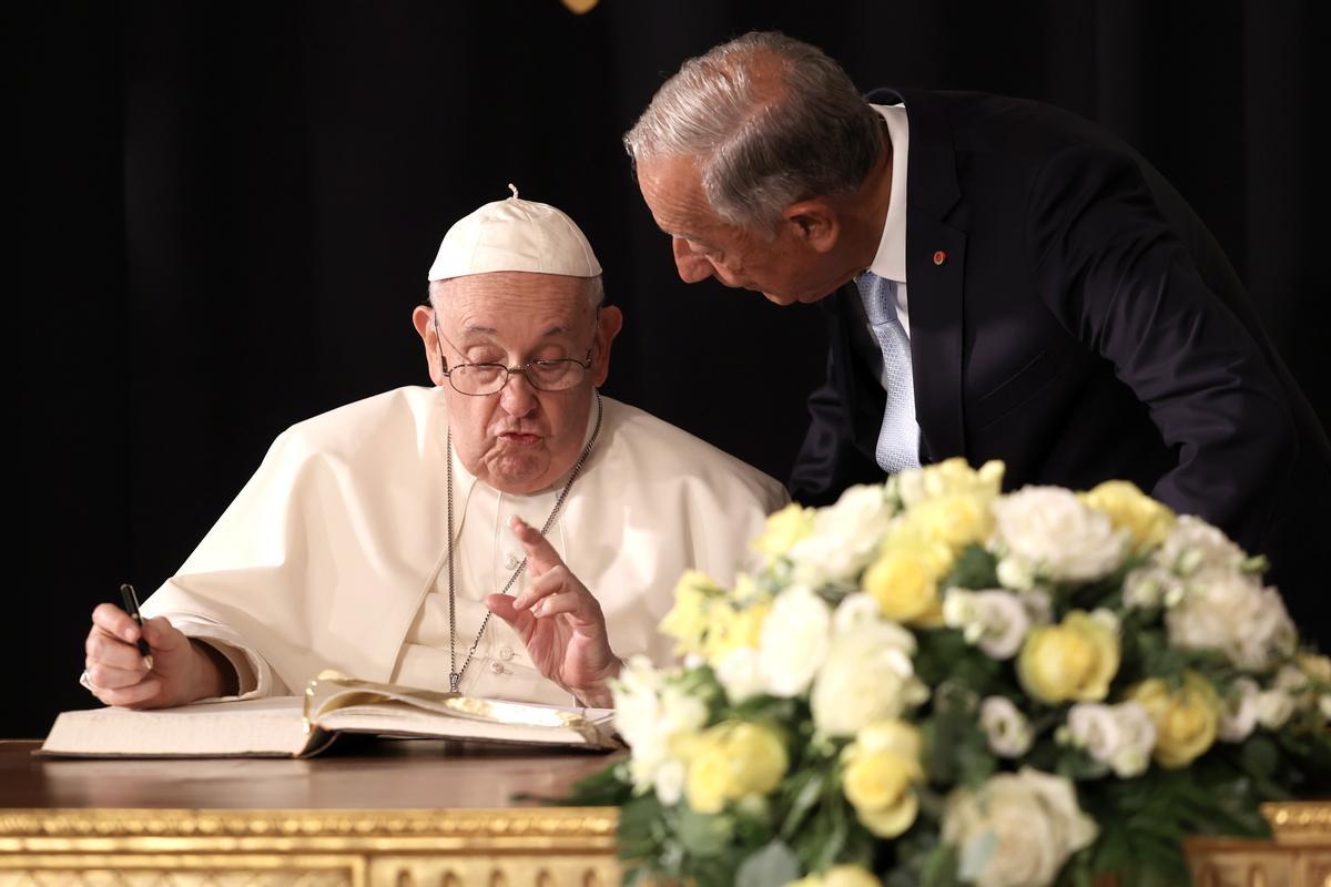 Lisbon (Portugal), 02/08/2023.- Pope Francis (L) signs the book of honor next to Portugal’s President Marcelo Rebelo de Sousa (R) during his welcome ceremony at Belem Palace in Lisbon, Portugal, 02 August 2023. The Pontiff is in Portugal on the occasion of World Youth Day (WYD), one of the main events of the Church that gathers the Pope with youngsters from around the world, that takes place until 06 August. (Papa, Lisboa) EFE/EPA/ANDRE KOSTERS / POOL