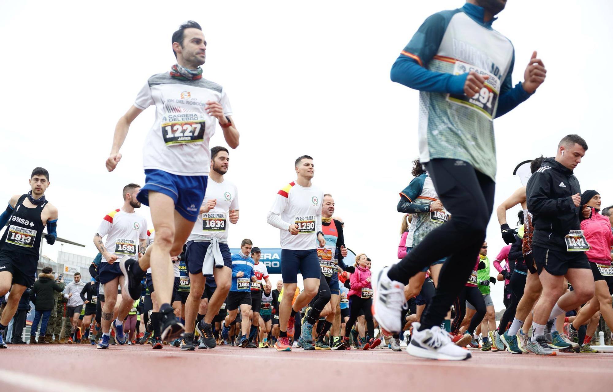 En imágenes | La lluvia no desanima a los participantes de la Carrera del Ebro