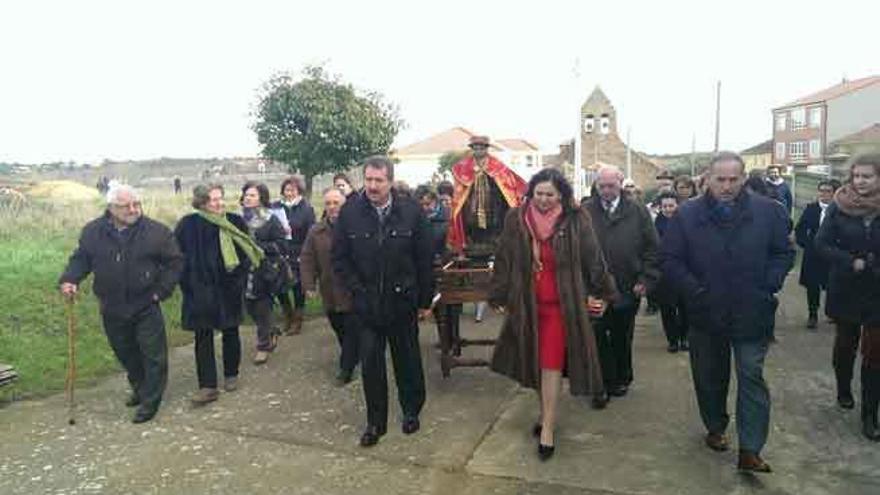 Procesión con San Tirso por las calles del pueblo. A la derecha, varios vecinos sacan la imagen del templo. Foto M. A. C.