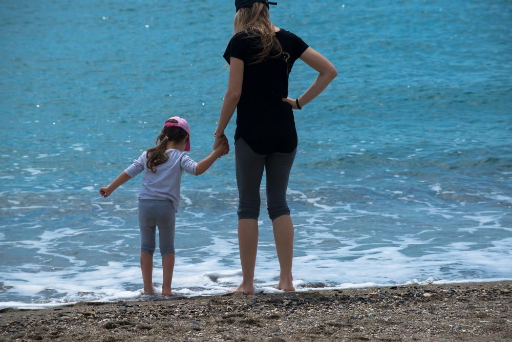 Padres e hijos aprovechan el primer día del desconfinamiento parcial de los niños menores de 14 años para dar un paseo por calles y plazas del Centro de Málaga. En la playa, algunos pequeños aprovechaban para remojarse los pies, bordeando una de las prohibiciones de esta nueva medida.