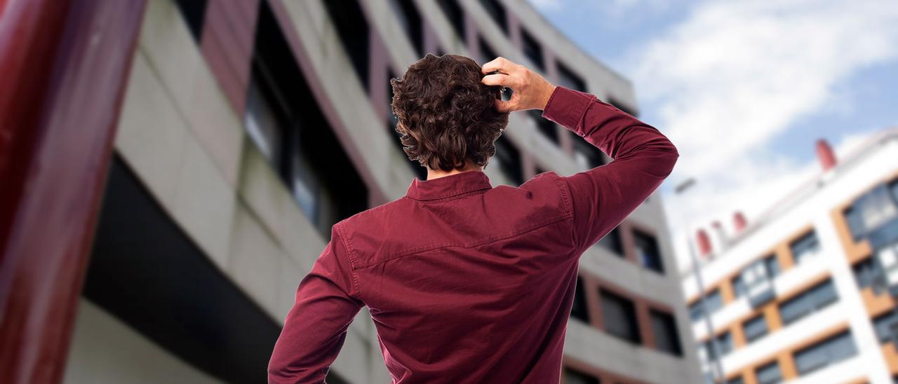 Un joven observando un edificio de Hispanidad con pisos en alquiler