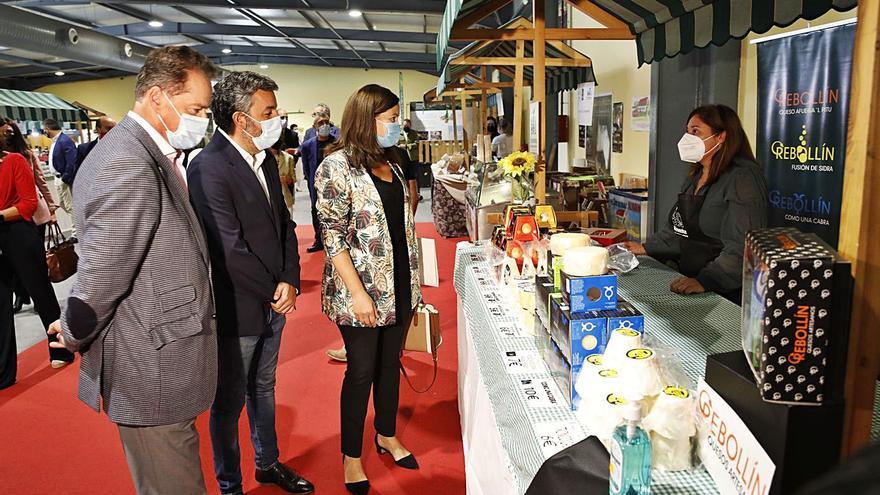 Por la izquierda, Félix Baragaño, Alejandro Calvo y Begoña López (directora general de Desarrollo Rural), ayer, ante uno de los stands de quesos de Agropec. | Ángel González