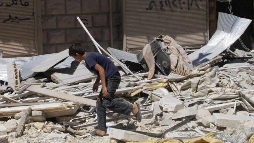 Un joven busca entre los escombros de un edificio atacado en Alepo.