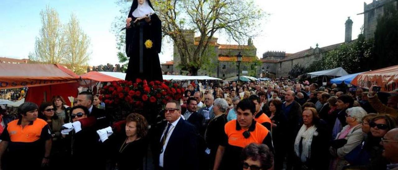 La imagen de Santa Rita, portada por un grupo de costaleras, y seguida por una multitud de fieles por las calles de Vilagarcía. // Iñaki Abella