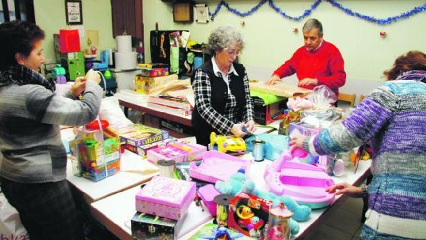 Miembros de la Asociación de Vecinos «Los Ríos» empaquetan juguetes donados para la celebración de Reyes.