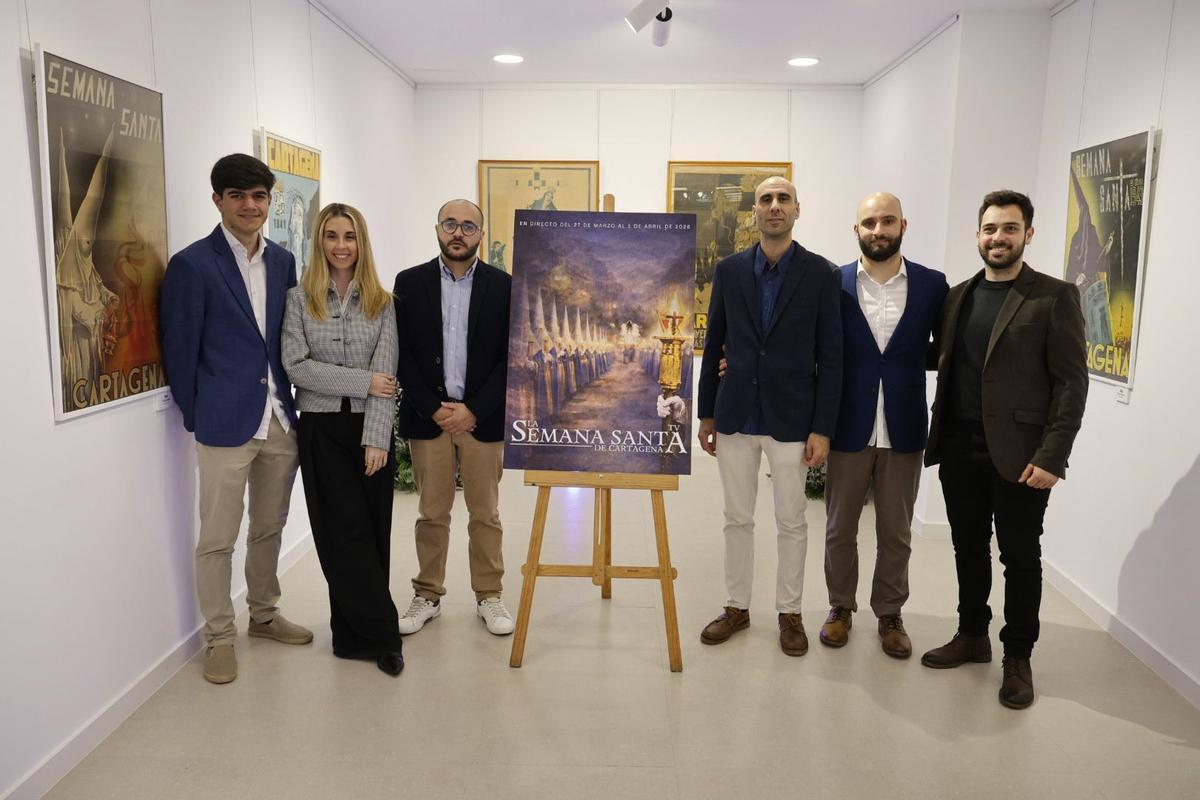 Seis componentes de ‘La Semana Santa de Cartagena TV’, con su cartel de 2026.