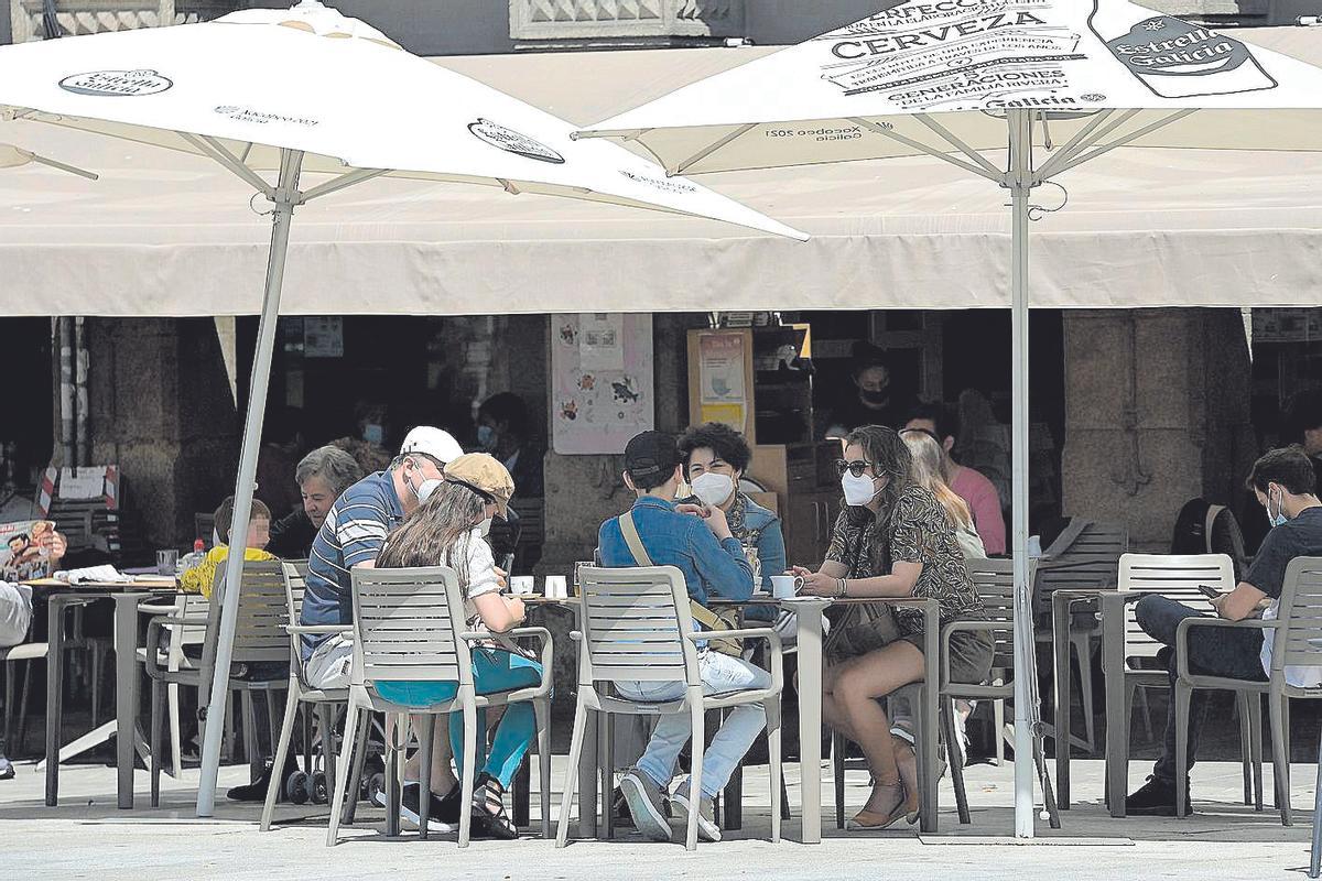 Varias personas toman algo en una terraza.