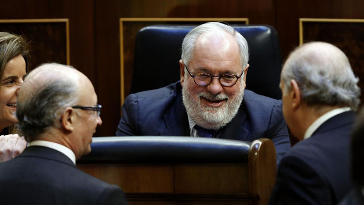 Miguel Arias Cañete, felicitado por los ministros Báñez, Montoro y Fernández Díaz, esta mañana, en el Congreso.