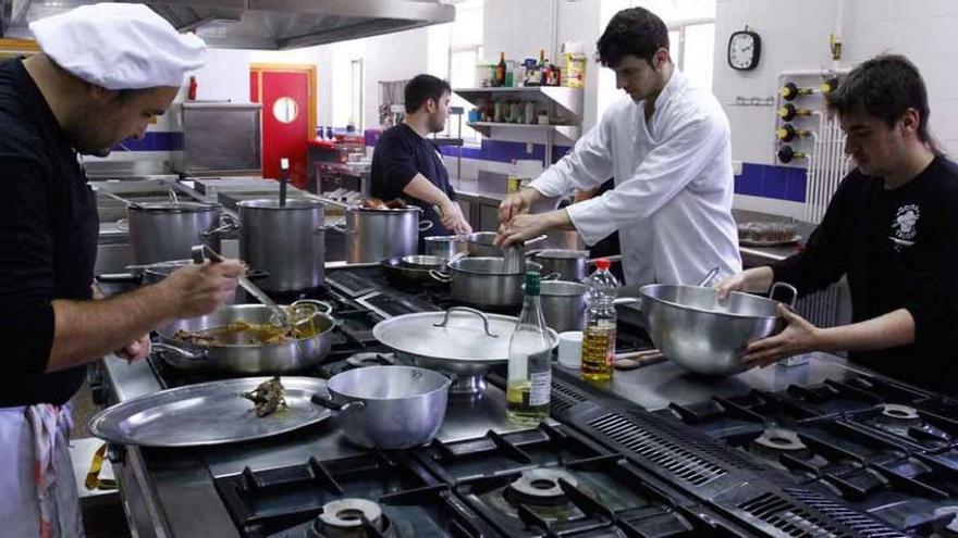 Arriba, los alumnos preparan los platos que servirán en el concurso Cocinando Calidad, organizado por el CIFP Ciudad de Zamora. A la izquierda, tres de los miembros del jurado prueban los platos elaborados por los estudiantes y los valoran. A la derecha, dos de los alumnos de uno de los grupos que participan en el concurso elaboran uno de los platos que posteriormente presentarán al jurado para intentar alzarse con el premio.