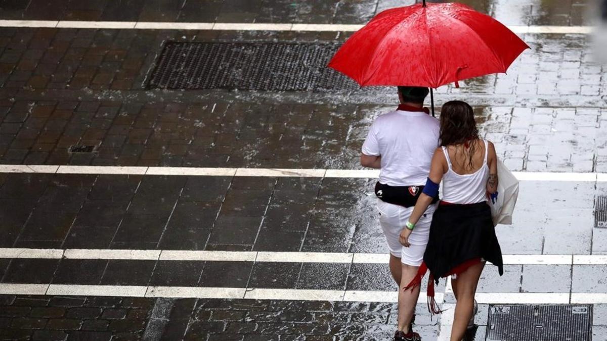 Dos personas se protegen de la lluvia