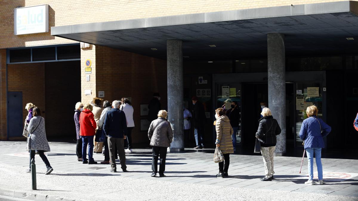 Fila de personas esperando para vacunarse en un centro de salud de Zaragoza.
