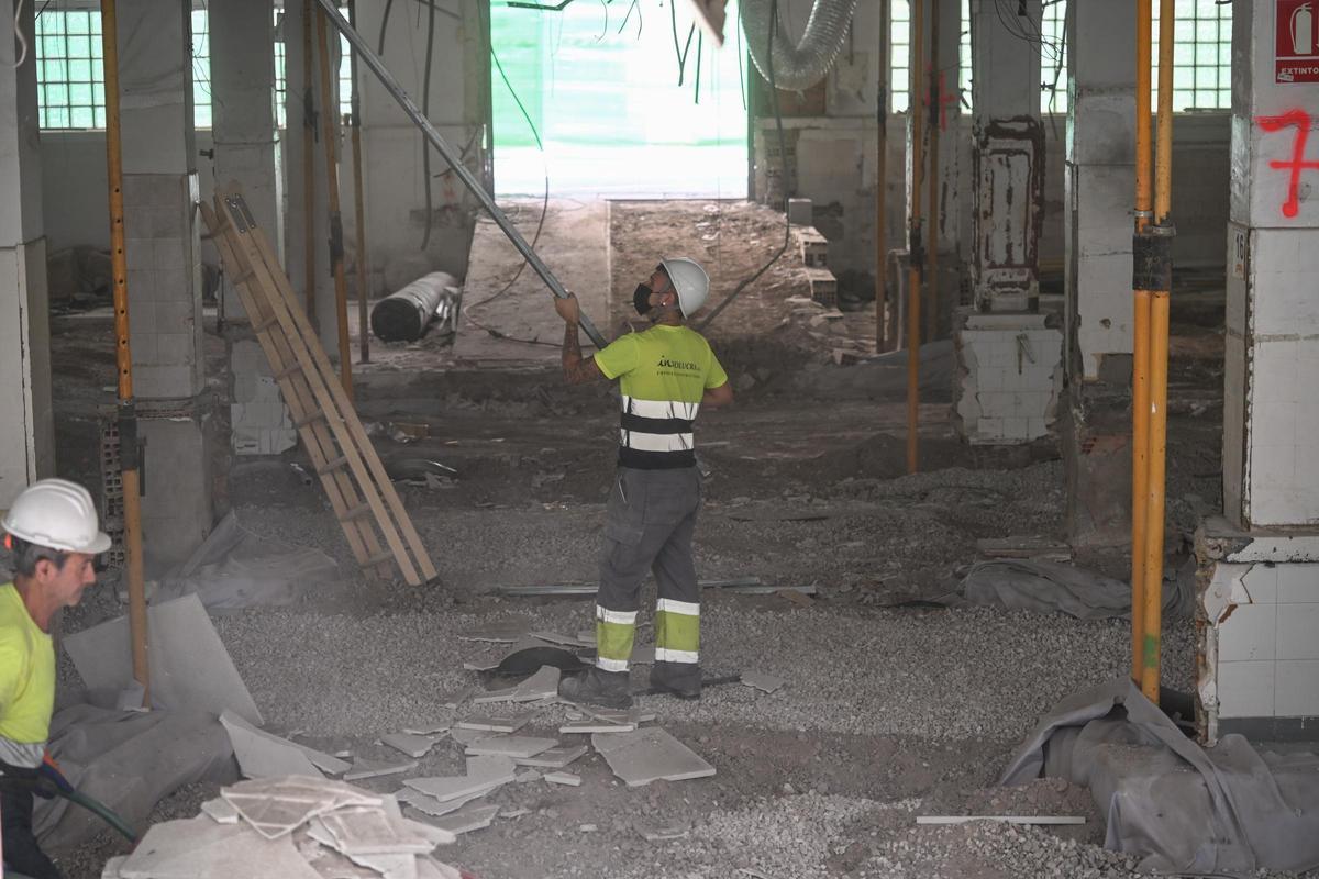 El interior del Mercado Central, donde ya se pueden ver los restos que aparecieron en la primera planta tapados, con un operario trabajando este martes.