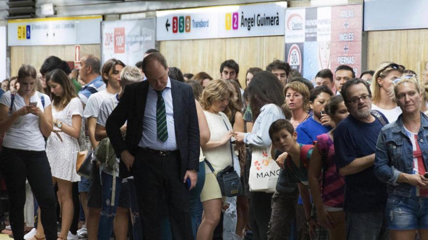 Viajeros en el andén de Àngel Guimerà. Foto: David Castillo