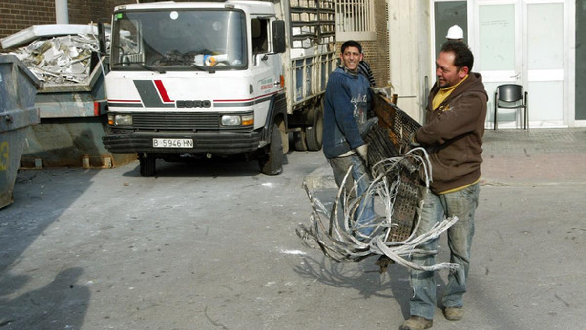 Unos chatarreros recogen cable eléctrico en las inmediaciones del Hospital de Can Ruti.