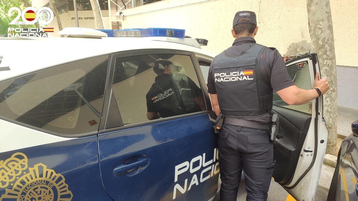 Un agente de la Policía Nacional entra en su coche patrulla en la Jefafura de Palma.