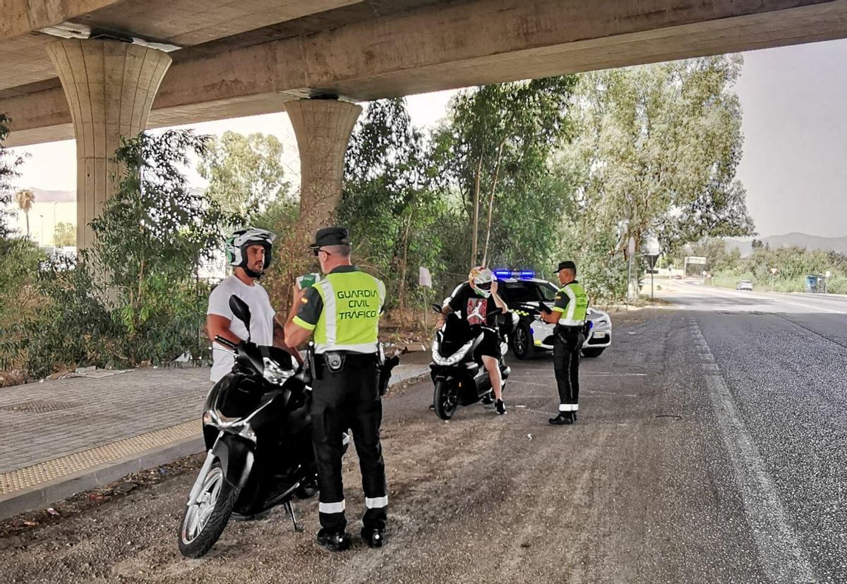 Una pareja de la Guardia Civil, junto a dos motoristas en un control junto a Mercamálaga.