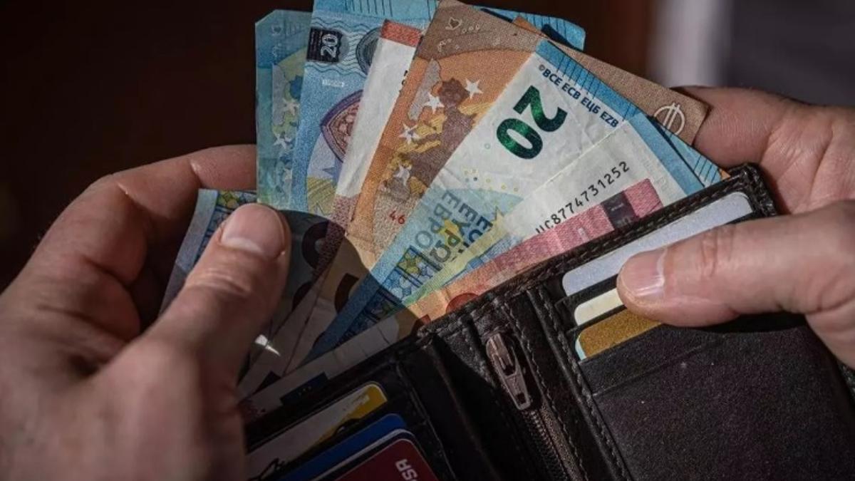 Un monedero con tarjetas y billetes de euros.