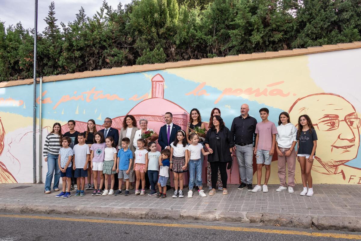 Pilar Roig posa en el mural junto a un grupo de alumnos.