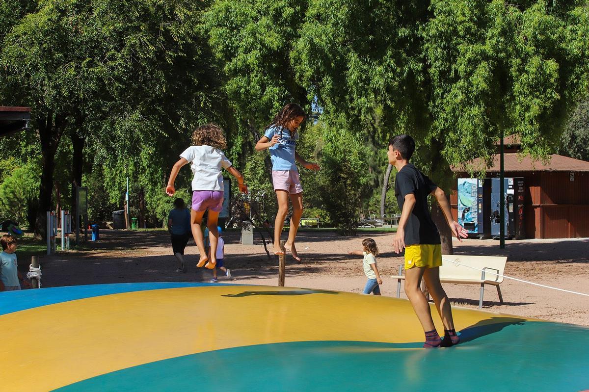 Unos niños saltán en una de las tracciones de la Ciudad de los Niños de Córdoba.