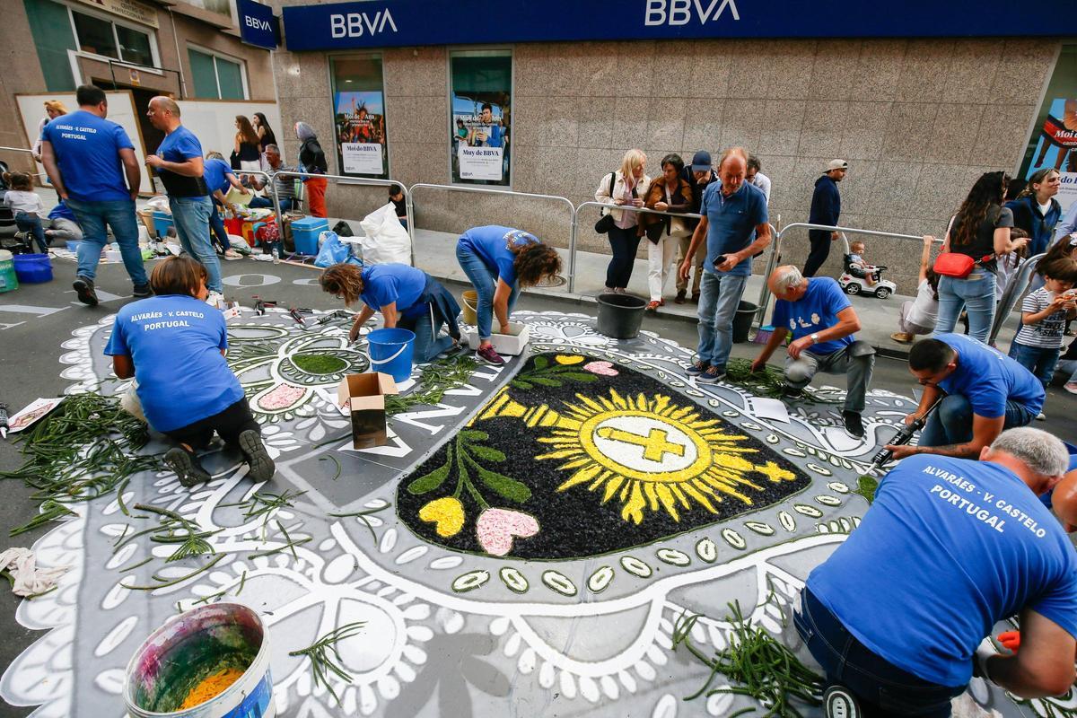 Unos alfombristas durante las labores en las calles.