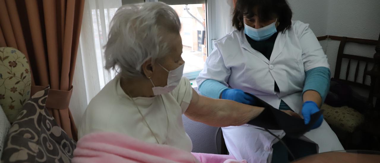 Una cuidadora de ayuda a domicilio atiende a una anciana en una imagen de archivo.