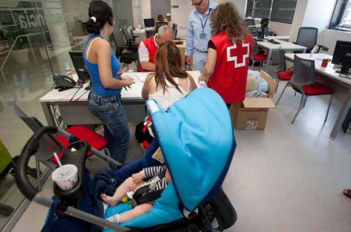 Miembros de Cruz Roja de Alicante, entregando productos infantiles este verano.