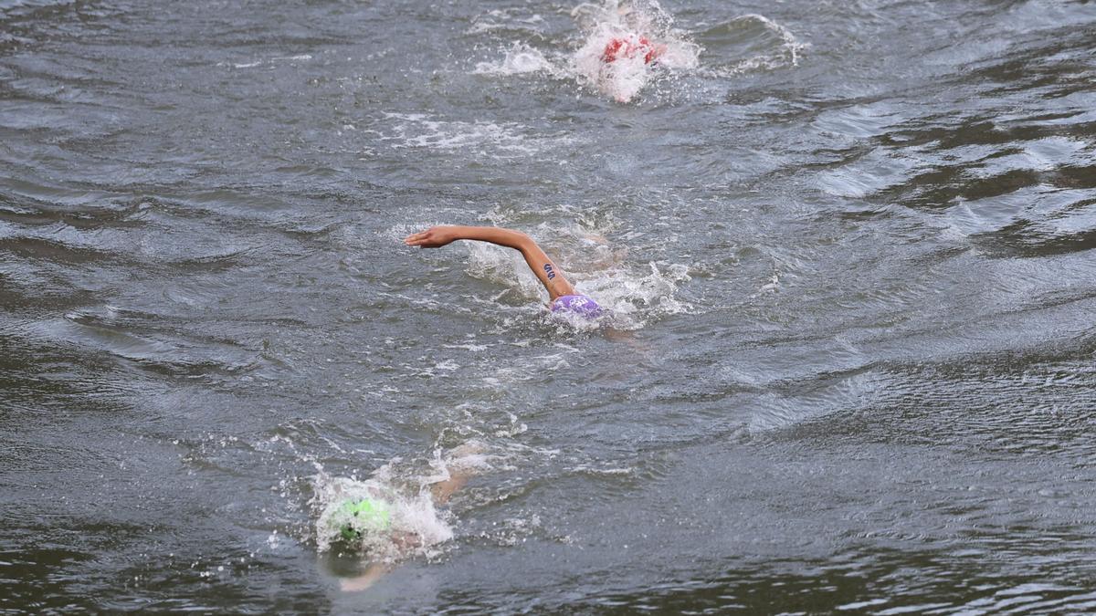 La triateta italiana Bianca Seregni (c) disputa en el río Sena la primera etapa de la prueba de triatlón femenino de los Juegos Olímpicos de París 2024.