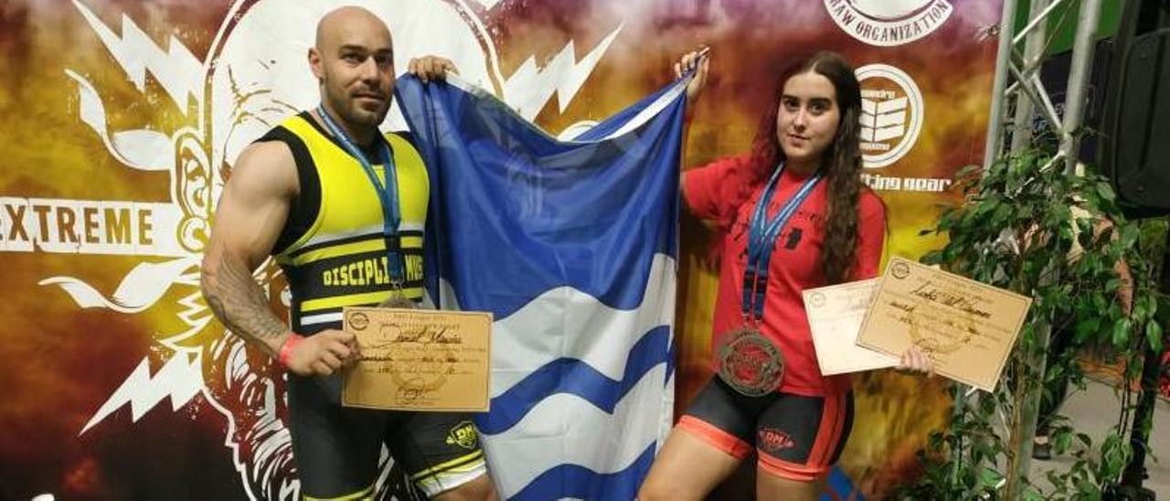 Daniel Maroñas y Aroha Novas con sus medallas en el mundial y la bandera de Bueu.   | // D.M.