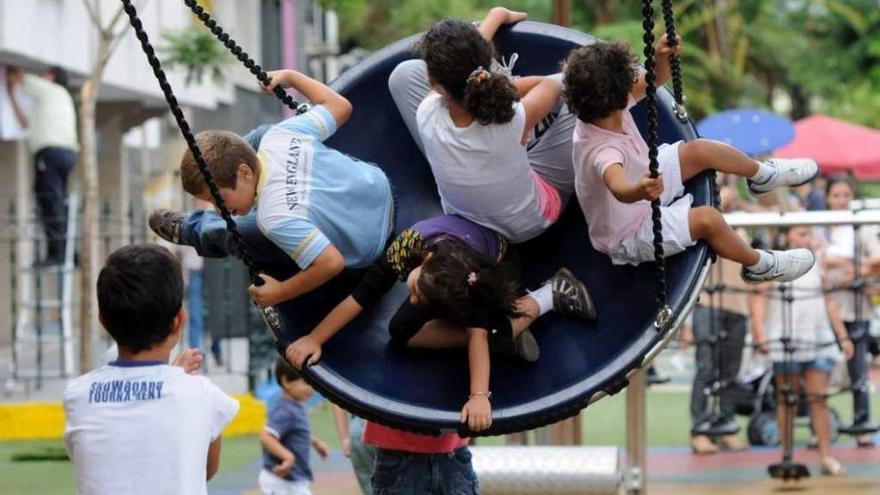 Varios niños juegan en un parque infantil.