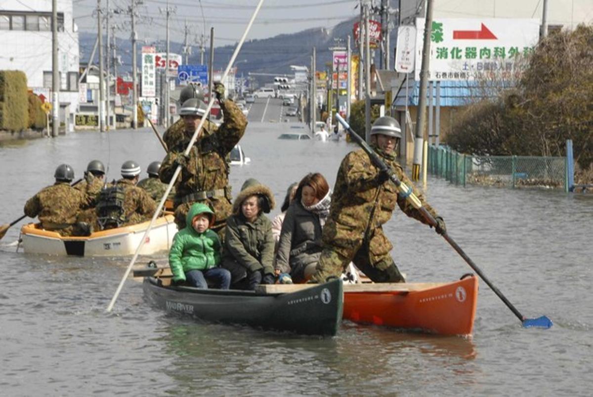 Oficials de defensa rescaten en barca els afectats pel tsunami a Ishinomaki City.