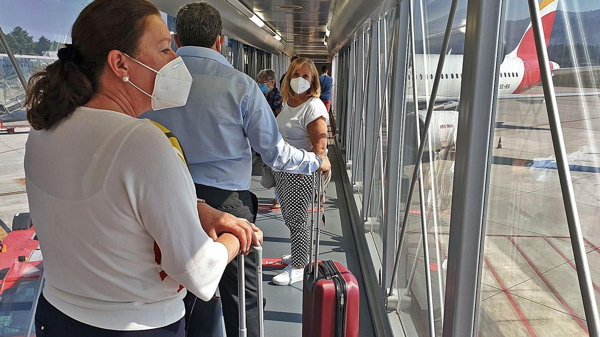Viajeros en la pasarela de acceso y salida del avión en el aeropuerto de Peinador. |