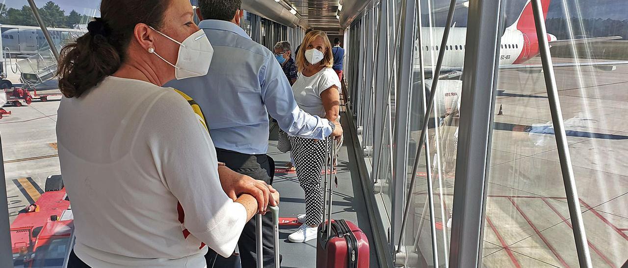 Viajeros en la pasarela de acceso y salida del avión en el aeropuerto de Peinador.