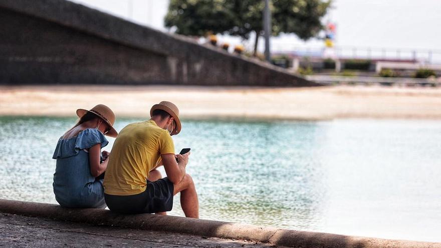 Dos personas huyen del calor hoy en Santa Cruz de Tenerife