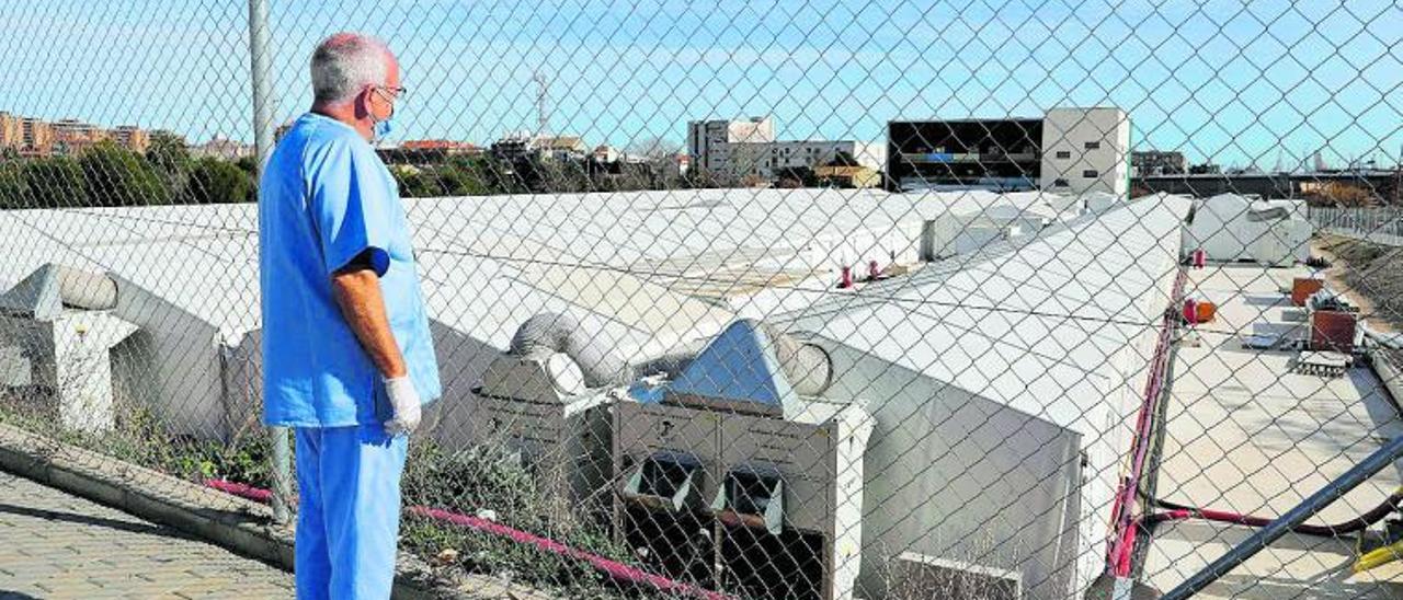 Un sanitario observa el hospital de campaña instalado en València junto a la Fe para dar respuesta a la presión asistencial. | F. BUSTAMANTE