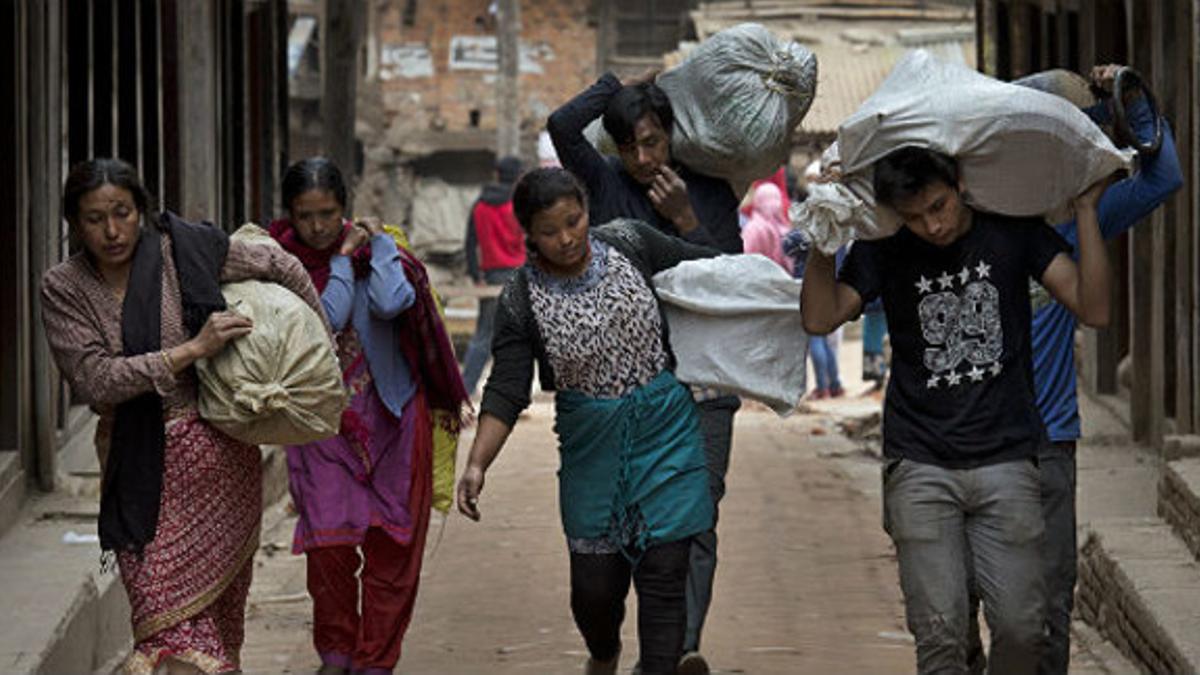 Ciudadanos de Bhaktapur, en Nepal, acarreando sus enseres.