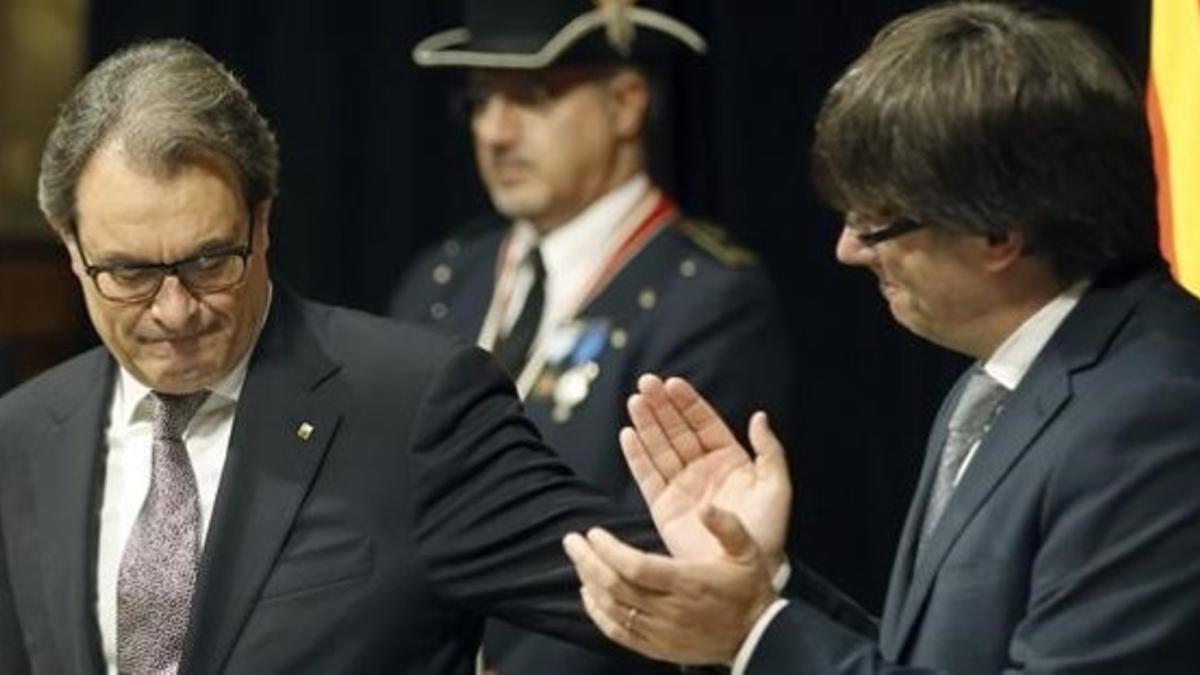 Artur Mas recibe el aplauso de Carles Puigdemont en la toma de posesión en la Generalitat.