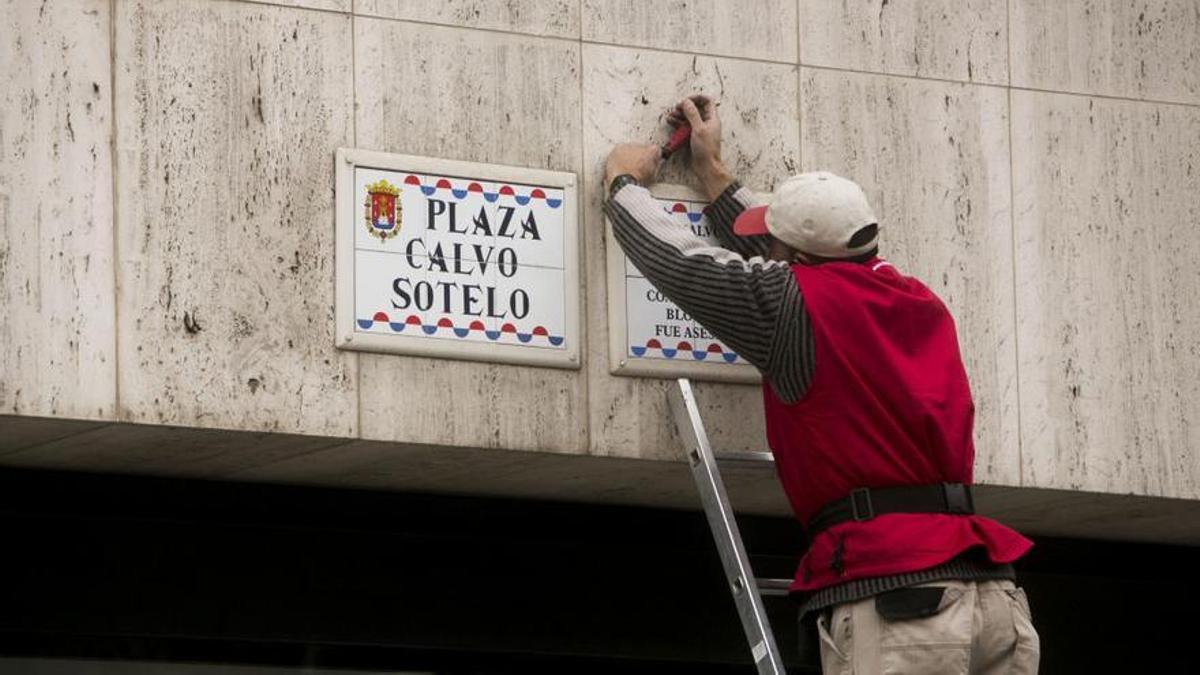Un operario cambia una placa en una calle de Alicante.