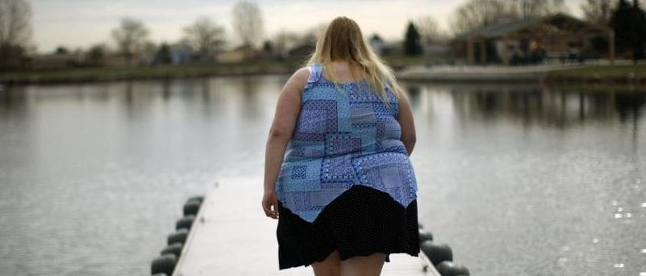 Una mujer con obesidad da un paseo por una dársena.