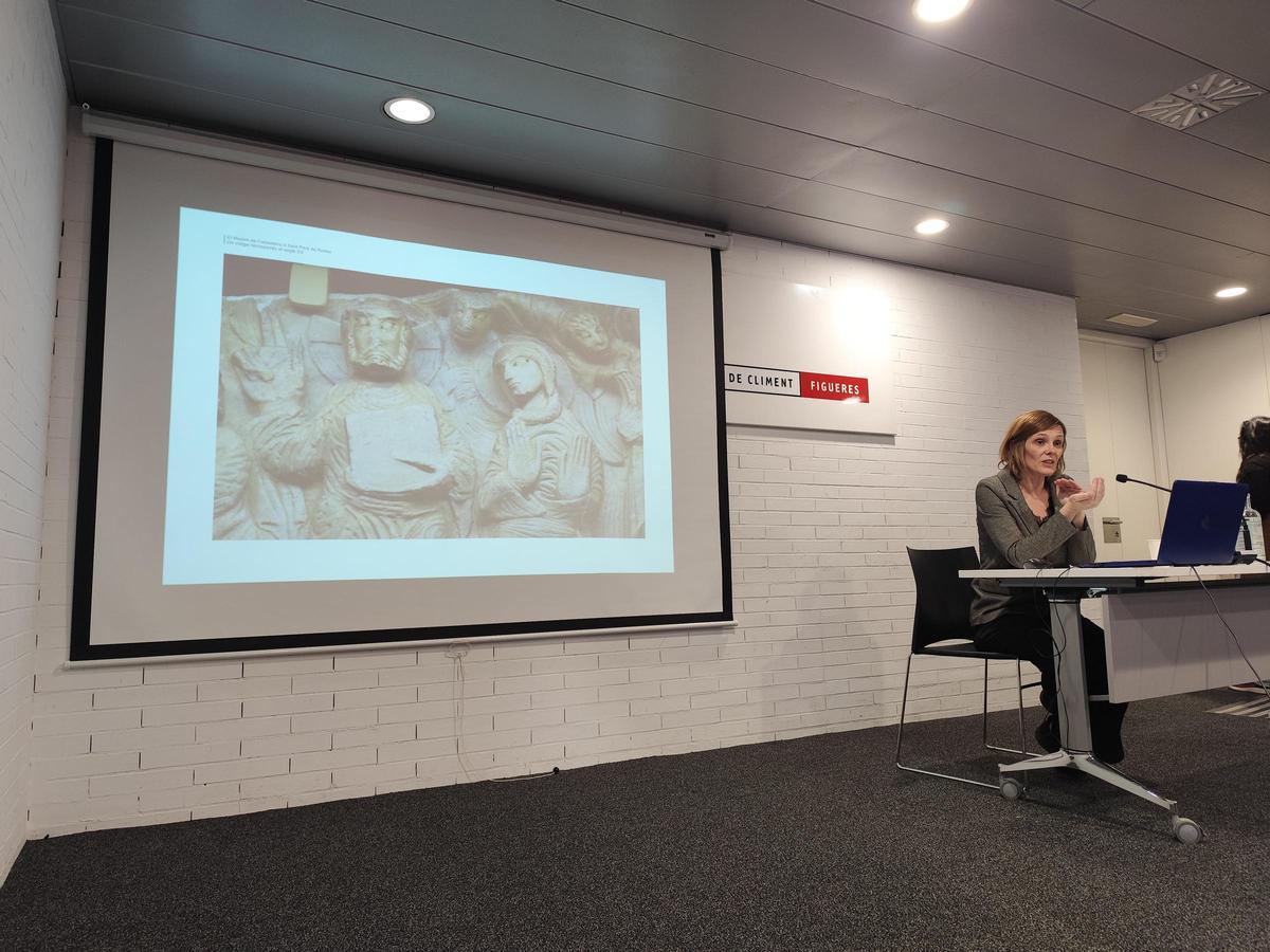 Laura Bartolomé mostrant, durant la conferència, una de les obres atribuïdes al mestre de Cabestany.