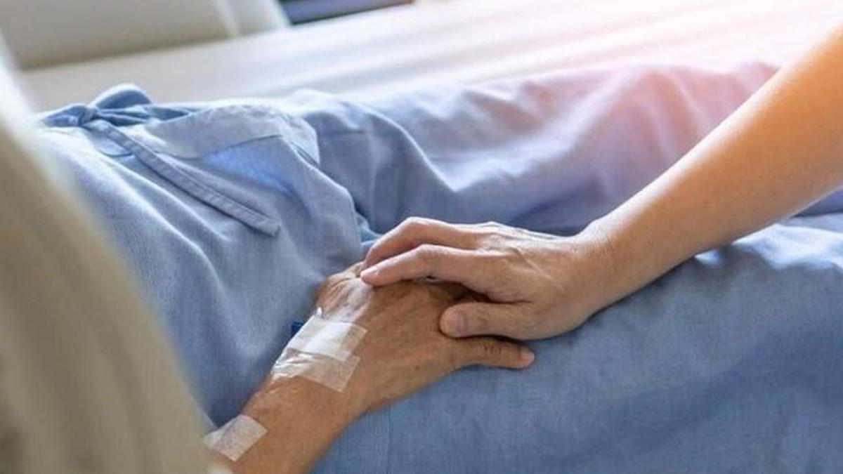 Una enfermera da la mano a una paciente