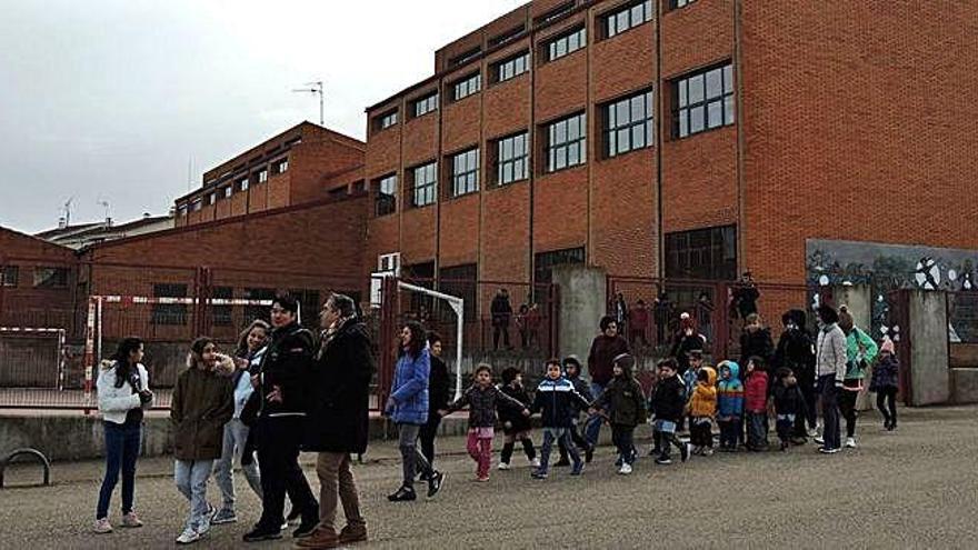 Profesores y alumnos saliendo del centro docente para llevar a cabo el paseo solidario.