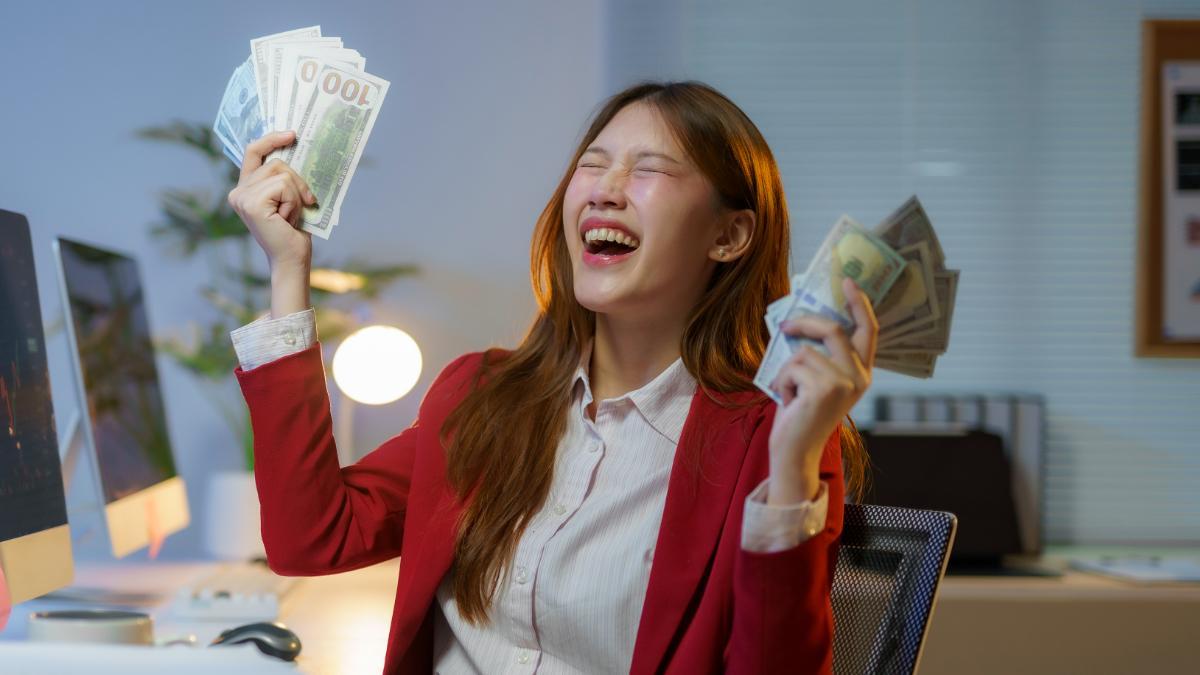 Empresaria emocionada con dinero en efectivo