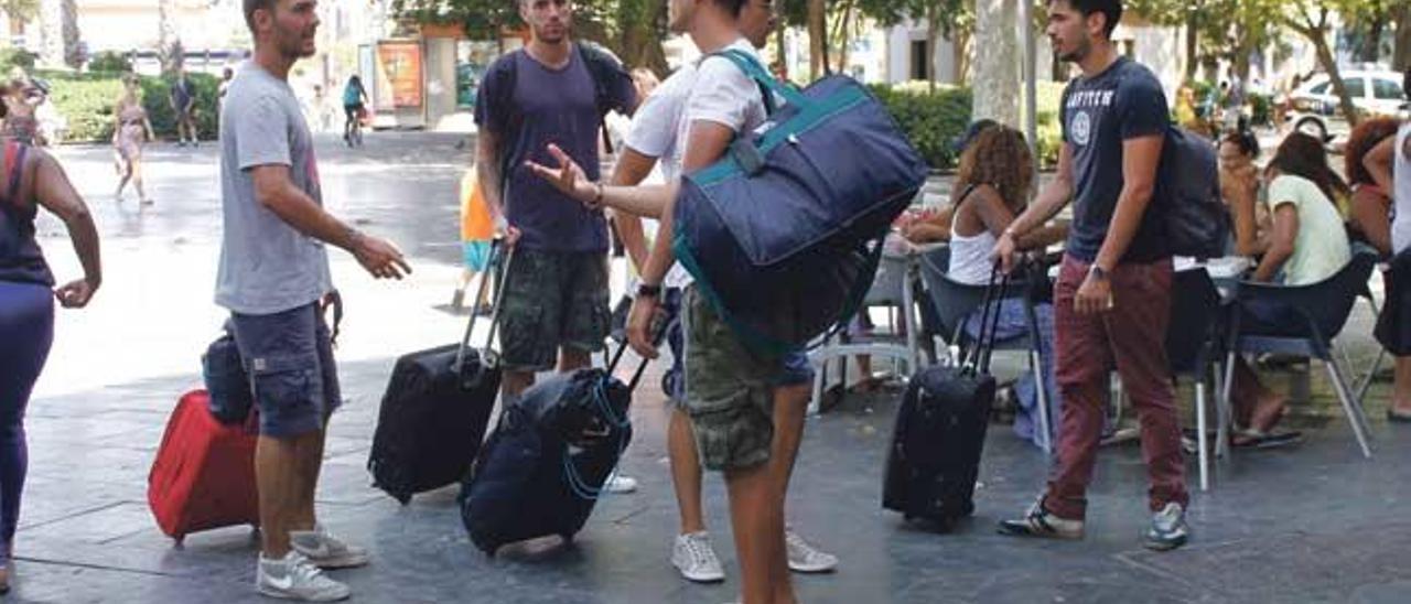 Un grupo de turistas extranjeros recién llegados en la Plaza de España con sus equipajes.