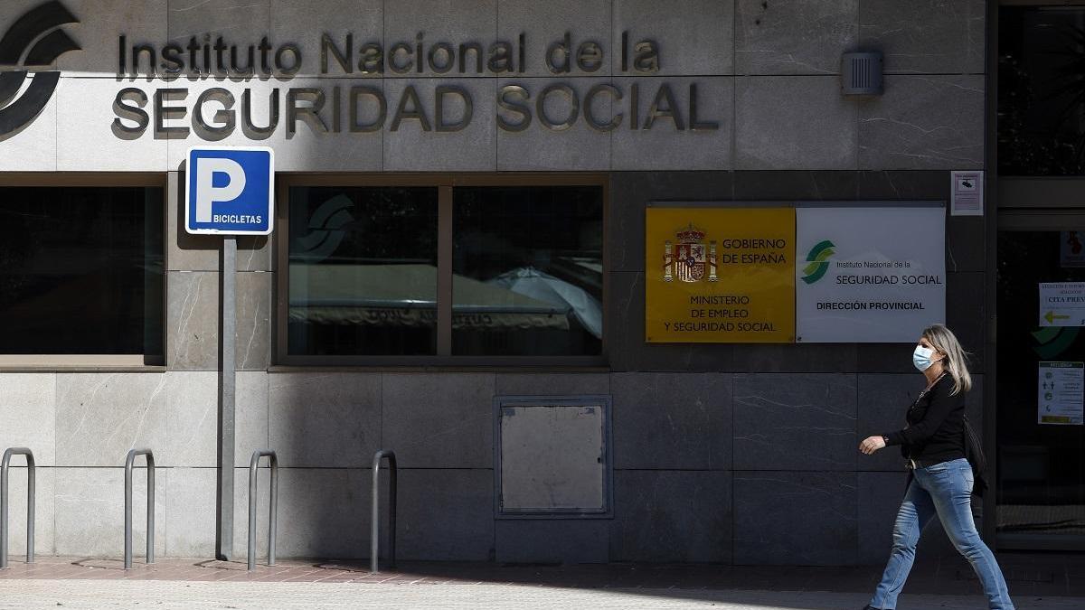 Una mujer pasa ante una oficina del Instituto Nacional de la Seguridad Social en Málaga.