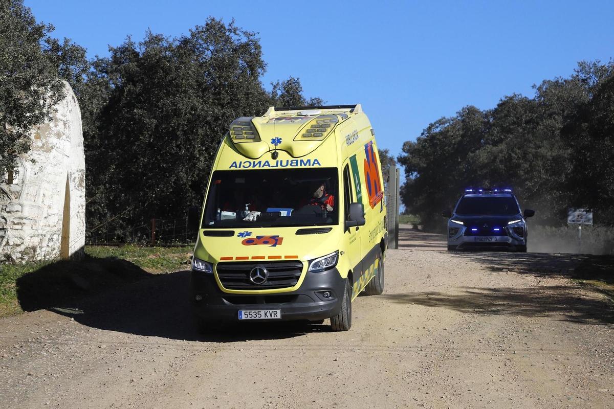 Una ambulancia del 061 abandona la base militar de Cerro Muriano seguida por un coche de la Guardia Civil.