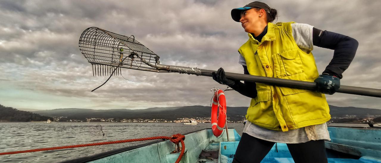 Ángeles Corredoira trabaja en su embarcación en el marisqueo a flote en la ría de Pontevedra.