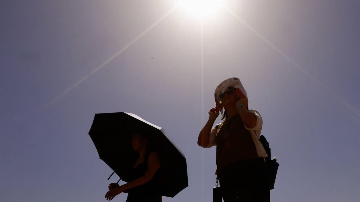 Viandantes se protegen del sol estos días en Córdoba.
