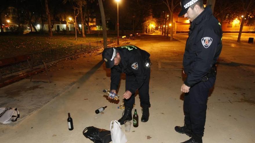 Policías locales de Murcia recogen los restos de un botelleo realizado en un parque próximo al centro de la ciudad.