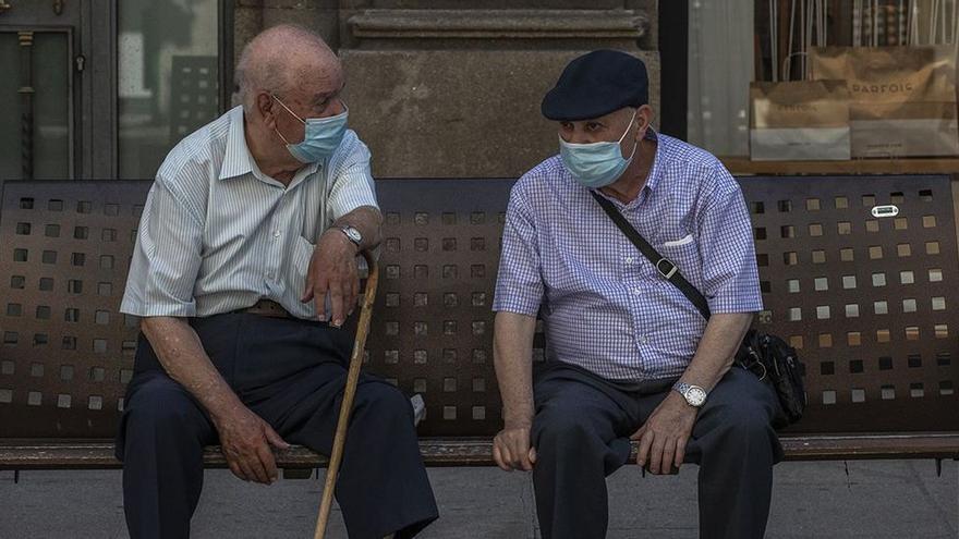 Dos personas charlan en una calle de Ourense.