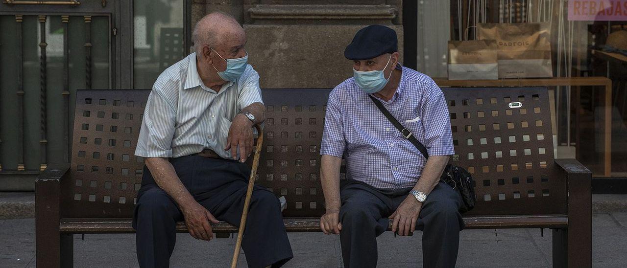 Dos personas charlan en una calle de Ourense.